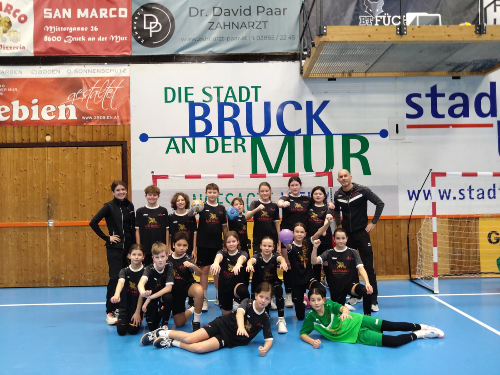 Eine Gruppe strahlender SportlerInnen im Turnsaal 