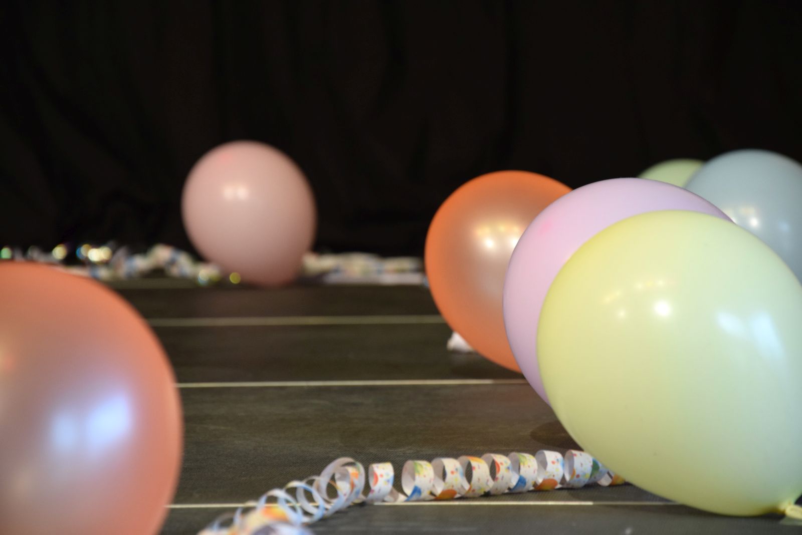 Ballons und Luftschlangen liegen auf einer Bühne 