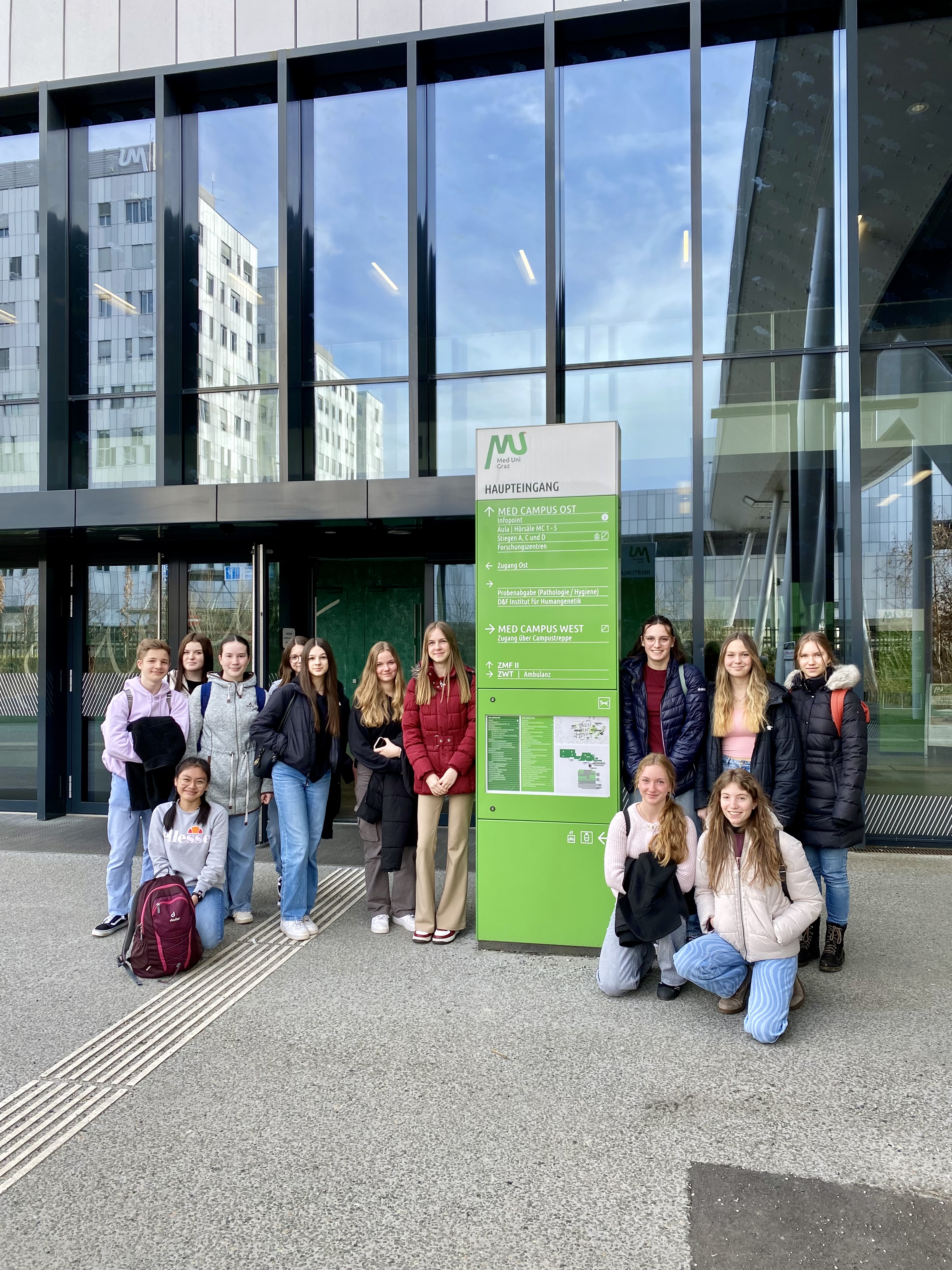 Eine Gruppe von Schüler:Innen steht vor der medizinischen Universität Graz 