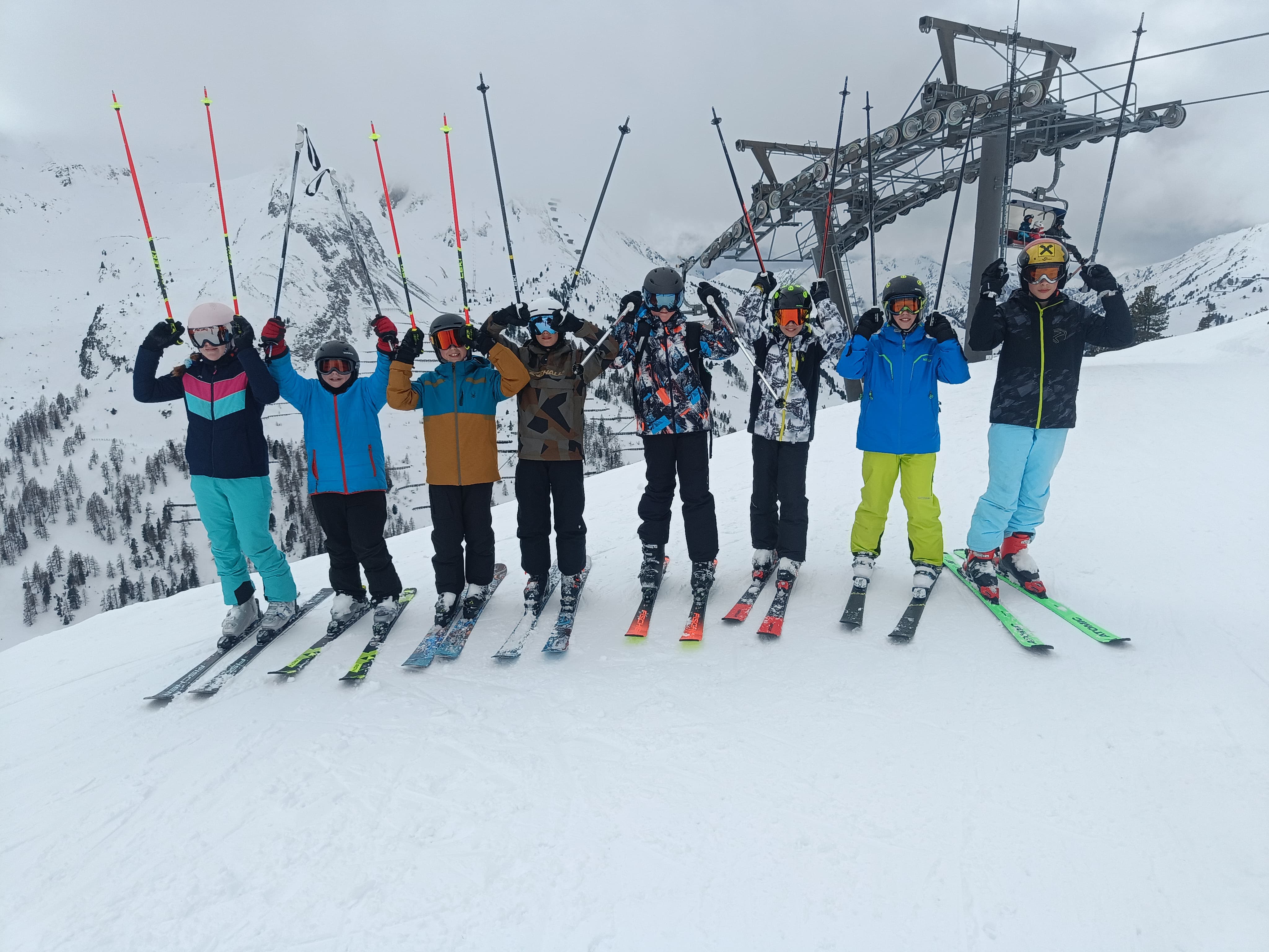 Gruppe von Schifahrerinnen halten ihre Stöcke nach oben